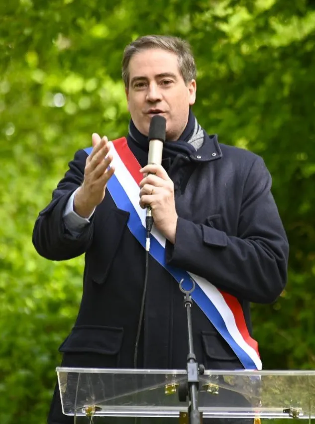 Olivier Becht, ceint de son écharpe tricolore, prononçant un discours