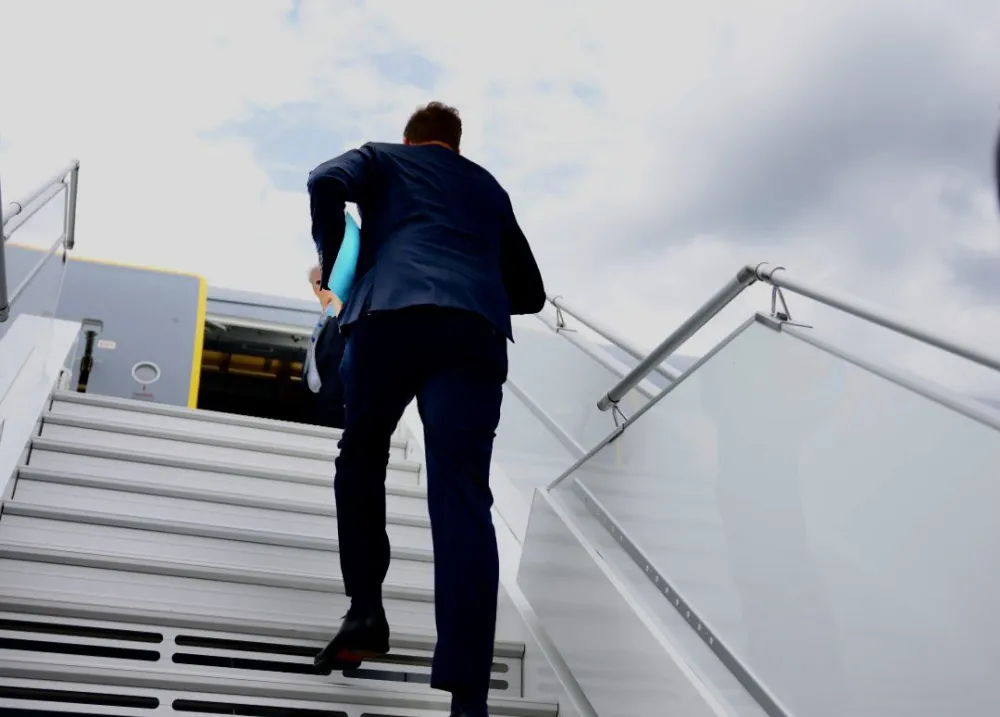 Olivier Becht montant la passerelle d’un avion