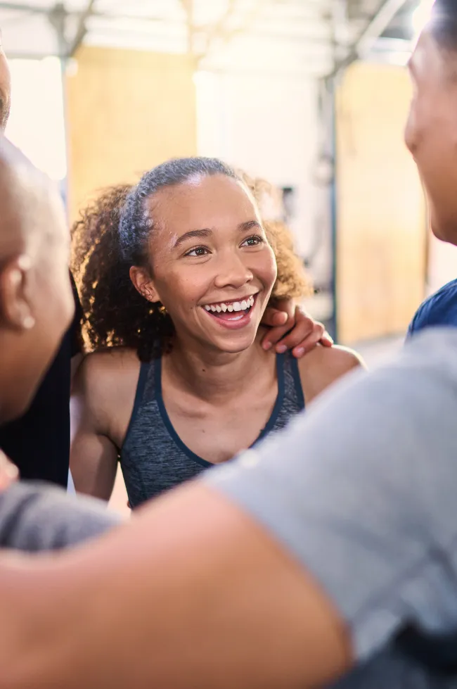 Une jeune femme souriante entourée de ses coéquipiers