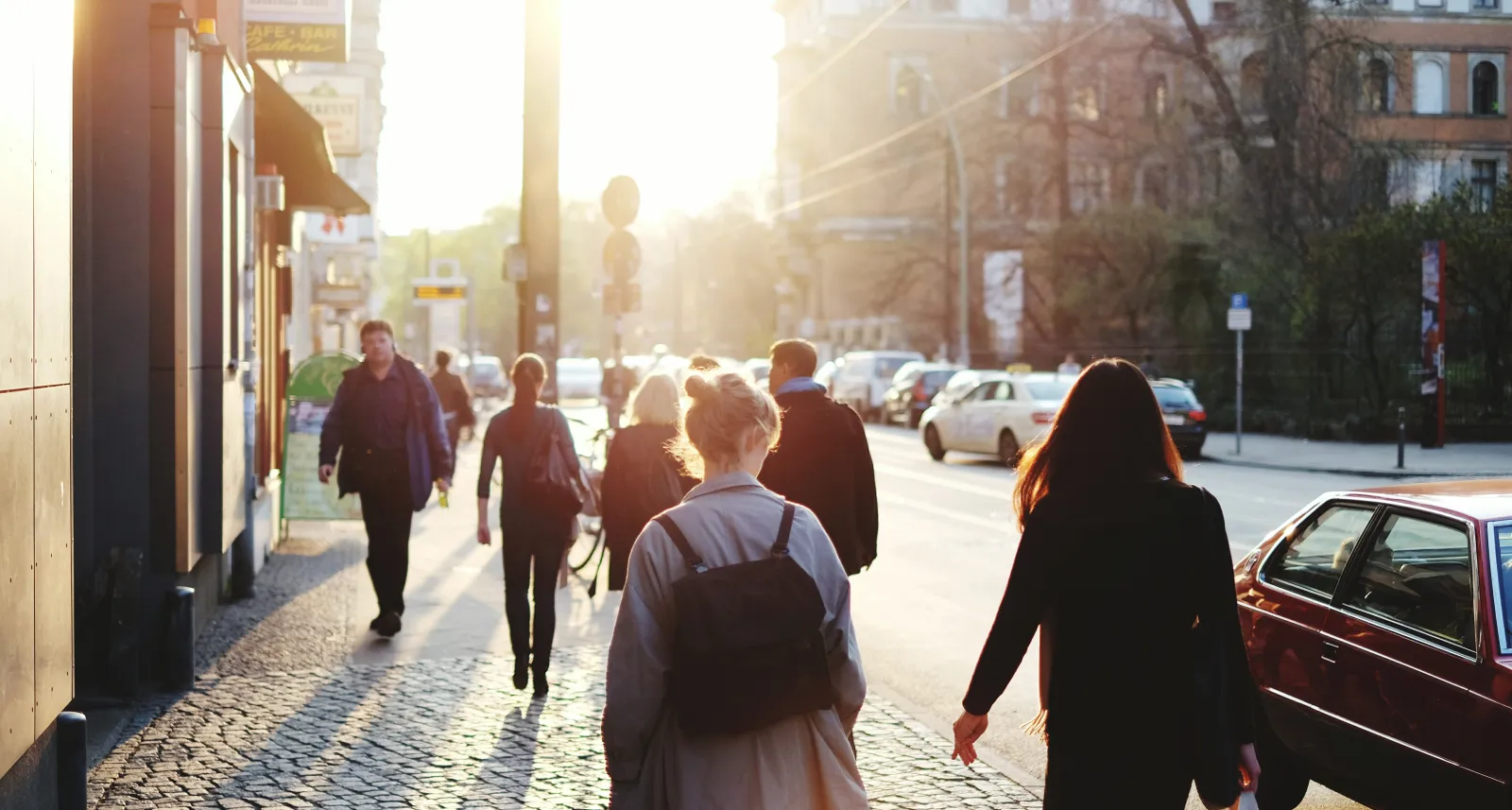 Passants sur un trottoir en ville, à contre-jour